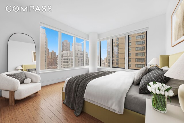 255 E 74th St Unit 14C, New York City, NY 10021 - bedroom with a skyline view and wood finished floors