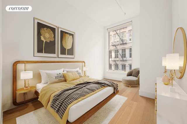 bedroom with visible vents, baseboards, and wood finished floors