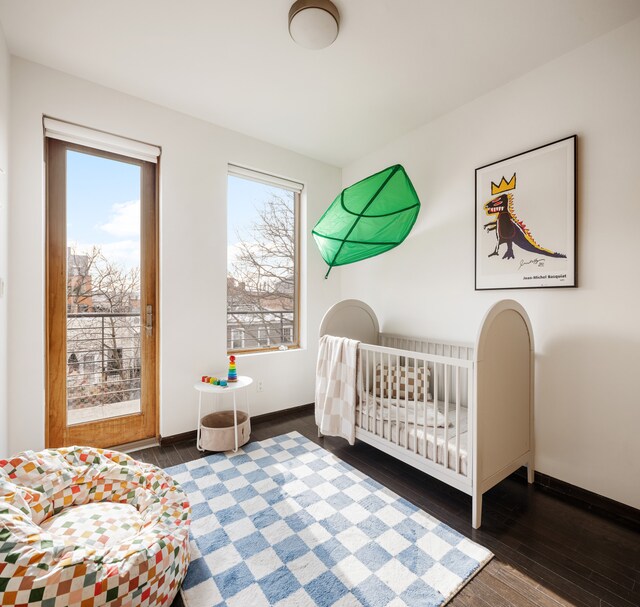 bedroom with multiple windows, hardwood / wood-style flooring, and baseboards