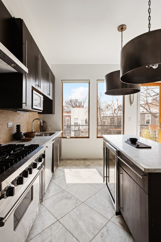 kitchen featuring range with gas cooktop, wine cooler, backsplash, light countertops, and hanging light fixtures
