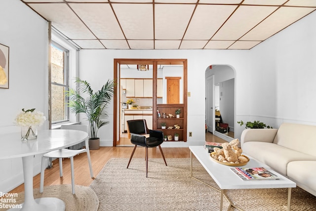 712 45th St Unit 3D, New York City, NY 11220 - living room with arched walkways, wood finished floors, and a paneled ceiling