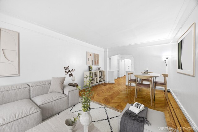 living room with baseboards and arched walkways