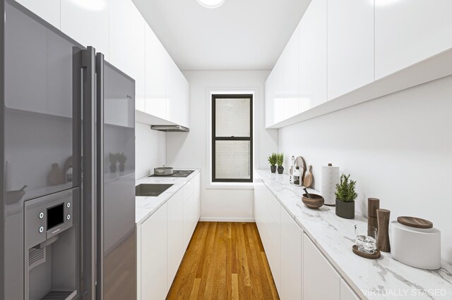 bar with baseboards, freestanding refrigerator, and light wood-type flooring