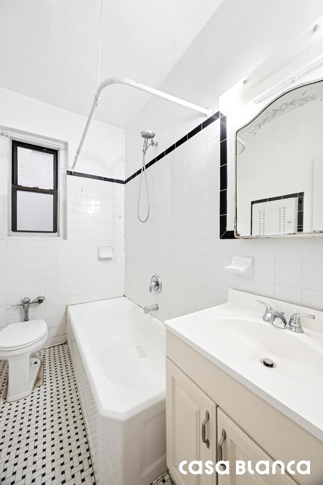 bathroom with vanity, shower / tub combination, toilet, and tile walls