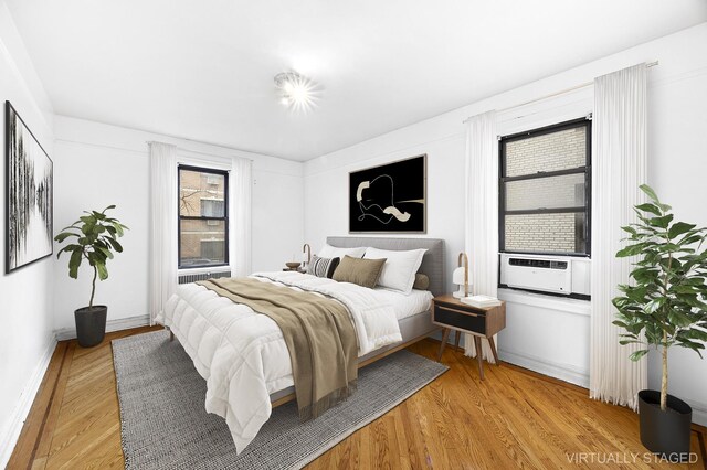 bedroom with cooling unit and light wood-type flooring