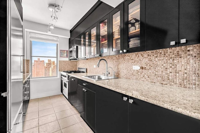 169 E 69th St Unit 19A, New York City, NY 10021 - kitchen with dark cabinets, high quality appliances, a sink, and backsplash