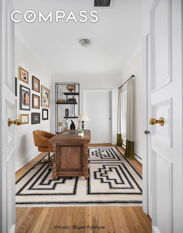 office space with a baseboard radiator, wood finished floors, crown molding, and visible vents