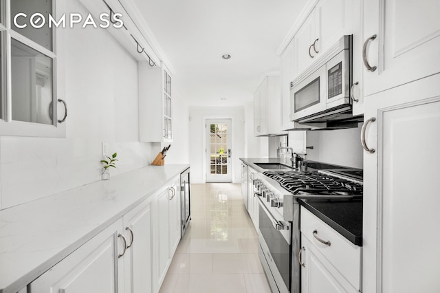 kitchen featuring high end range, light tile patterned floors, and white cabinetry
