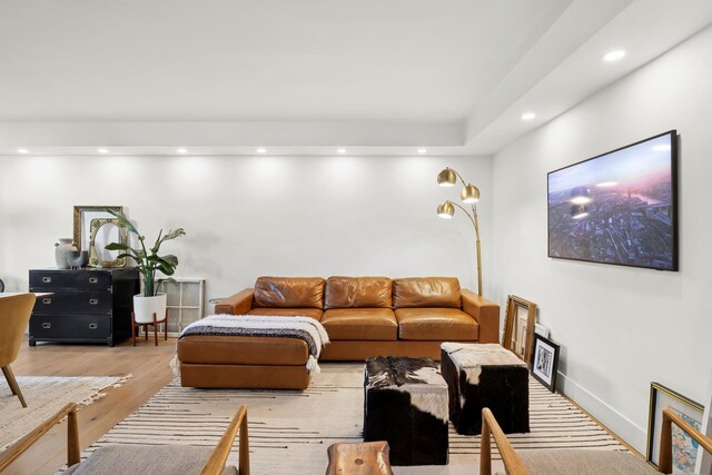 living area with baseboards, light wood finished floors, and recessed lighting