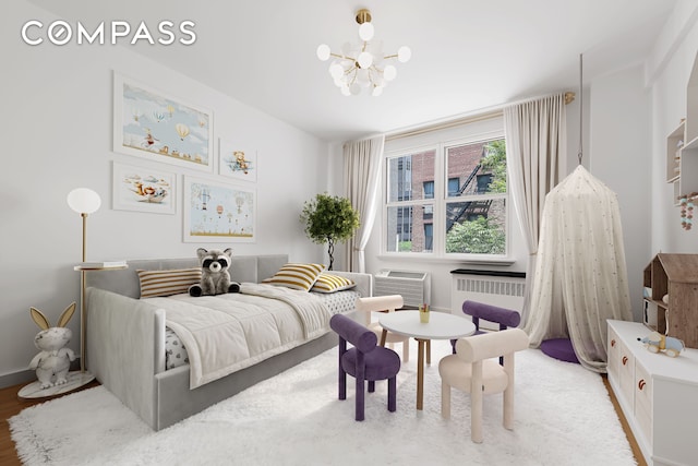 221 E 50th St Unit 6D/7D, New York City, NY 10022 - bedroom with a chandelier, radiator, and wood finished floors
