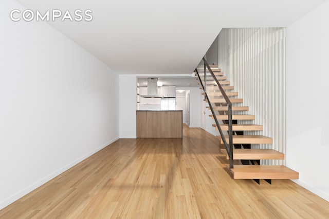staircase with baseboards and wood finished floors