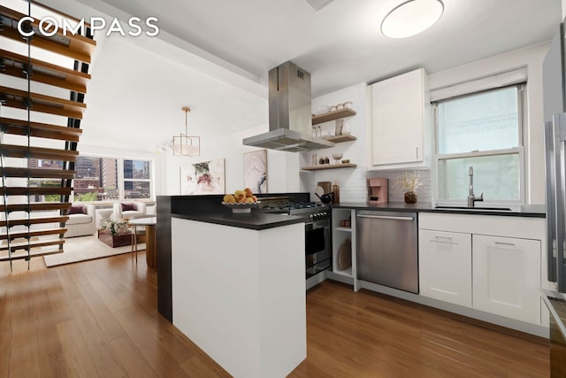 kitchen with open shelves, dark countertops, island range hood, a sink, and stainless steel appliances