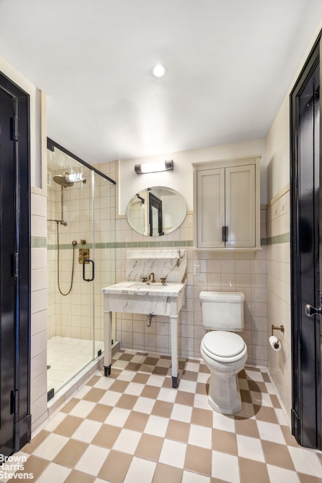 211 Elizabeth St Unit 5N, New York City, NY 10012 - bathroom with tile patterned floors, tile walls, toilet, a stall shower, and recessed lighting