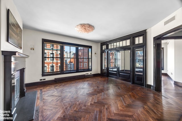 211 Elizabeth St Unit 5N, New York City, NY 10012 - unfurnished living room featuring baseboards, a glass covered fireplace, and baseboard heating