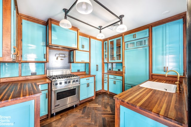 211 Elizabeth St Unit 5N, New York City, NY 10012 - kitchen featuring wooden counters, high end appliances, a sink, and glass insert cabinets