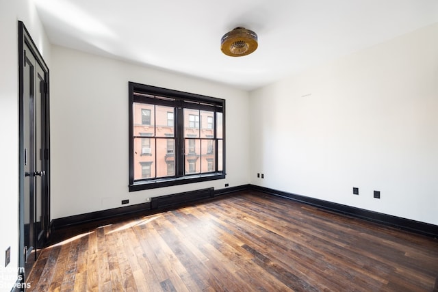 211 Elizabeth St Unit 5N, New York City, NY 10012 - empty room with dark wood-style flooring and baseboards