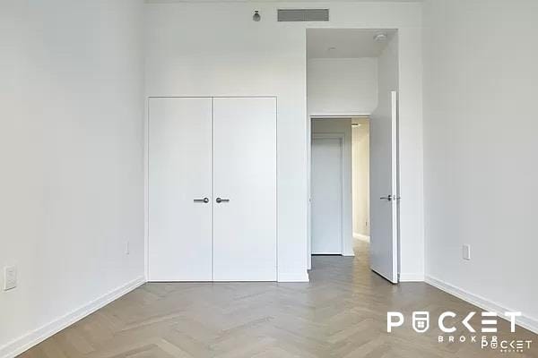 184 Kent Ave Unit C-614, New York City, NY 11249 - unfurnished bedroom featuring a closet and baseboards