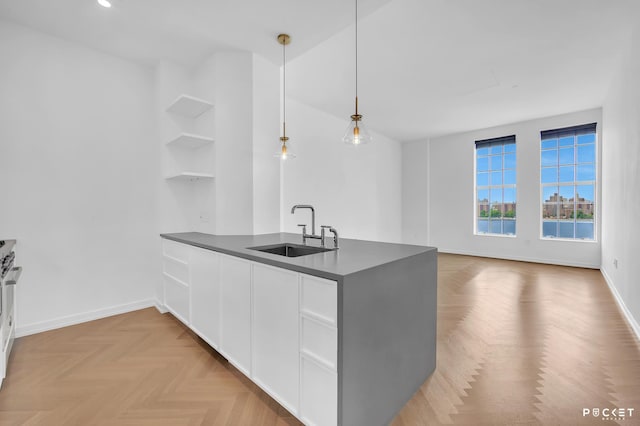 184 Kent Ave Unit C-614, New York City, NY 11249 - kitchen featuring dark countertops, a peninsula, open shelves, white cabinetry, and hanging light fixtures