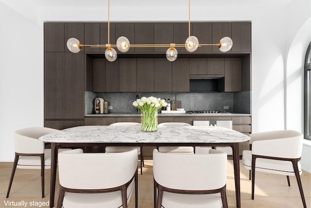 130 William St Unit 38D, New York City, NY 10038 - kitchen featuring modern cabinets, decorative backsplash, a breakfast bar, and stainless steel gas cooktop