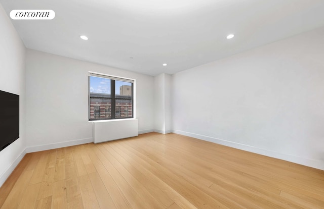 spare room with light wood-type flooring, baseboards, and recessed lighting