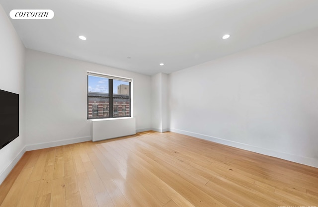 unfurnished room with light wood-style floors, baseboards, and recessed lighting