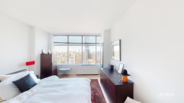 bedroom featuring radiator and a view of city