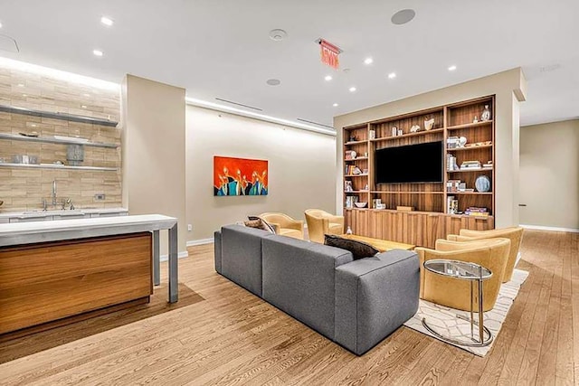 living area featuring baseboards, recessed lighting, and light wood-style flooring