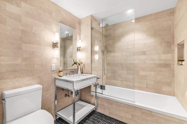 full bathroom with tile walls, tiled shower / bath, tile patterned floors, and toilet