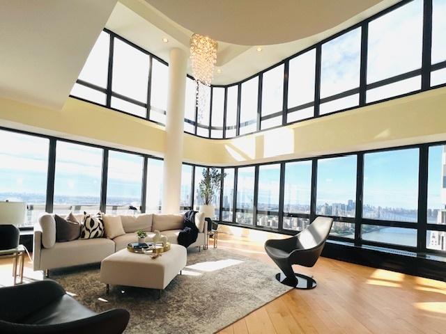 530 E 76th St Unit Ph35H36H, New York City, NY 10021 - living room with wood finished floors, a high ceiling, and a chandelier