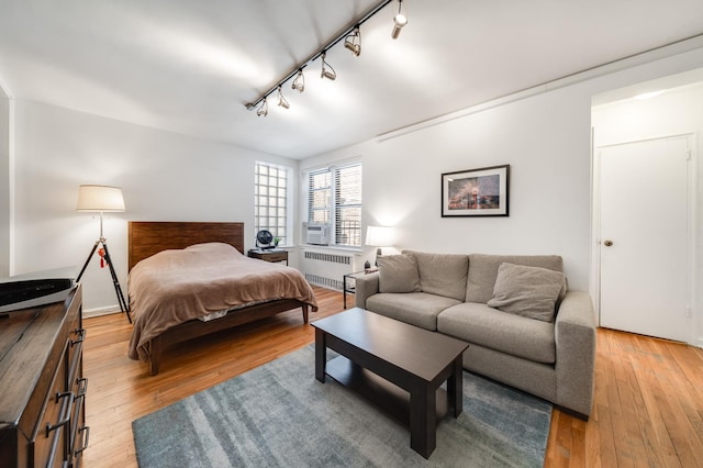 54 E 8th St Unit 6-L, New York City, NY 10003 - bedroom with radiator heating unit, rail lighting, light wood-type flooring, and cooling unit