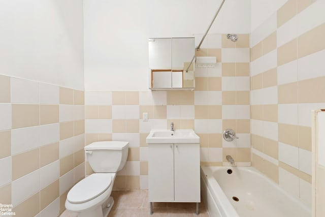 full bath featuring tile patterned flooring, tile walls, toilet, vanity, and tub / shower combination