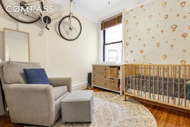31 Tiemann Pl Unit 37, New York City, NY 10027 - bedroom with wood finished floors, a crib, crown molding, and baseboards