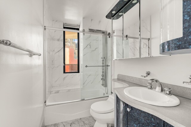 311 E 38th St Unit 7B, New York City, NY 10016 - full bath featuring vanity, marble finish floor, enclosed tub / shower combo, and toilet