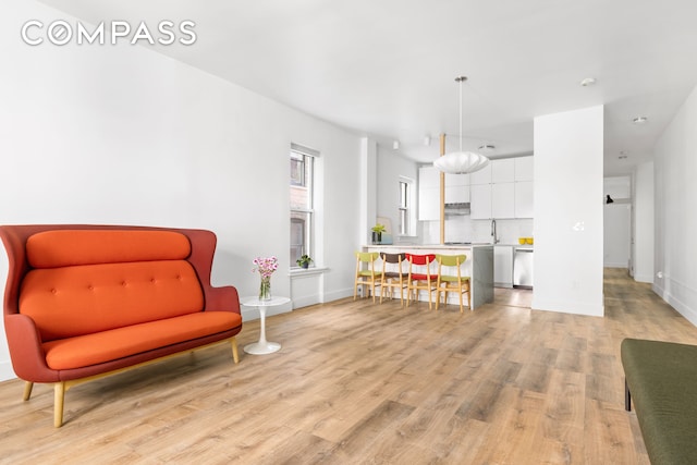 living area with light wood-style flooring and baseboards