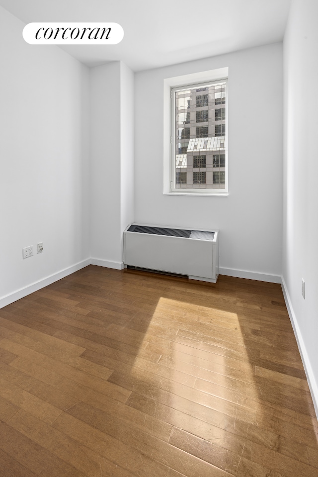 1600 Broadway Unit 17A, New York City, NY 10019 - spare room with radiator, wood finished floors, and baseboards
