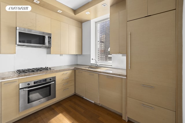 1600 Broadway Unit 17A, New York City, NY 10019 - kitchen featuring appliances with stainless steel finishes, a sink, dark wood-type flooring, and light stone countertops