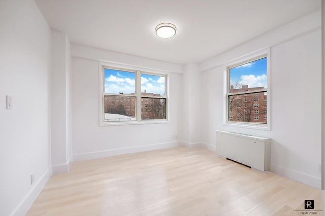 empty room with light wood finished floors and baseboards