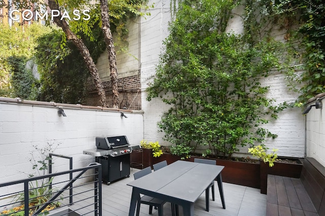 view of patio with fence, a wooden deck, outdoor dining area, and area for grilling