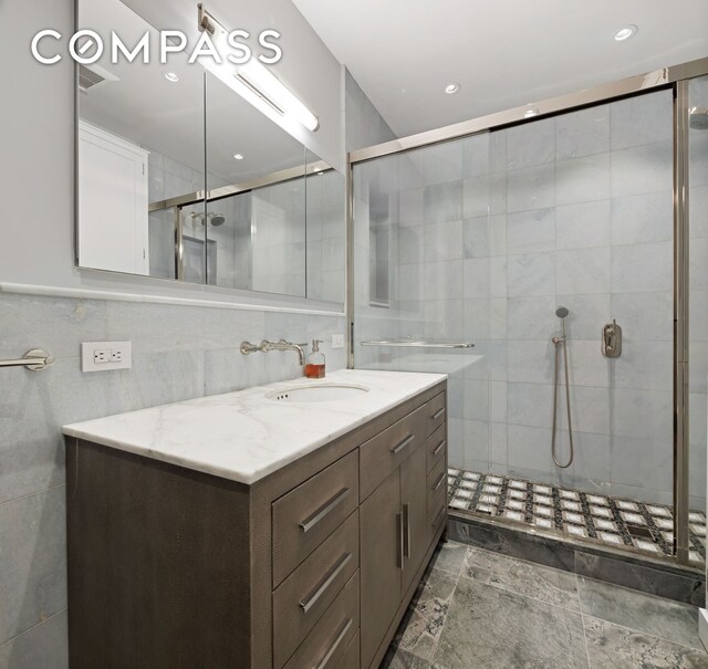 217 W 22nd St, New York City, NY 10011 - bathroom featuring tile walls, a stall shower, and vanity