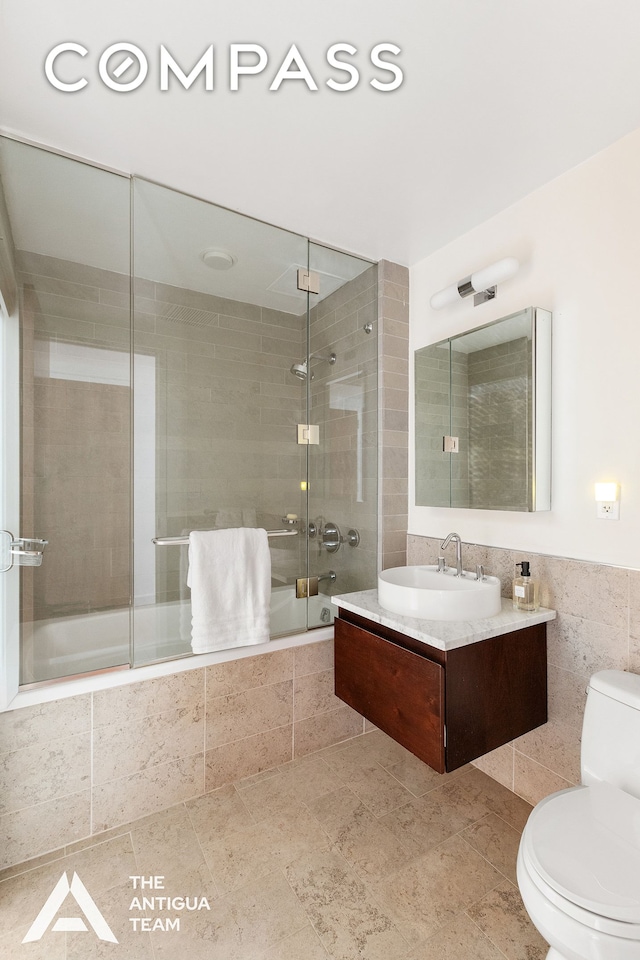 125 W 21st St Unit 12A, New York City, NY 10011 - bathroom featuring toilet, tiled shower / bath combo, vanity, and tile walls