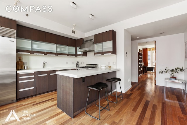 125 W 21st St Unit 12A, New York City, NY 10011 - kitchen with range hood, stainless steel built in fridge, modern cabinets, and a breakfast bar area