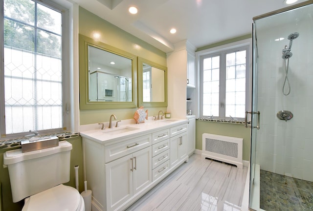 34 Fort Charles Place, New York City, NY 10463 - full bathroom with radiator heating unit, a stall shower, double vanity, toilet, and recessed lighting