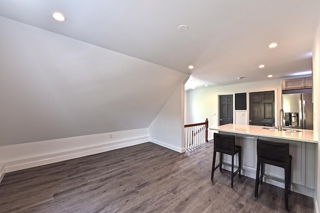 34 Fort Charles Place, New York City, NY 10463 - kitchen with stainless steel fridge, a sink, dark wood-type flooring, a breakfast bar area, and light countertops