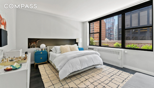 bedroom featuring baseboards, wood finished floors, and radiator