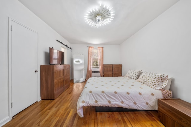 79-10 34th Ave Unit 3S, New York City, NY 11372 - bedroom with a barn door and wood finished floors