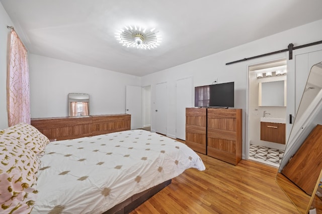 79-10 34th Ave Unit 3S, New York City, NY 11372 - bedroom featuring a barn door and light wood finished floors