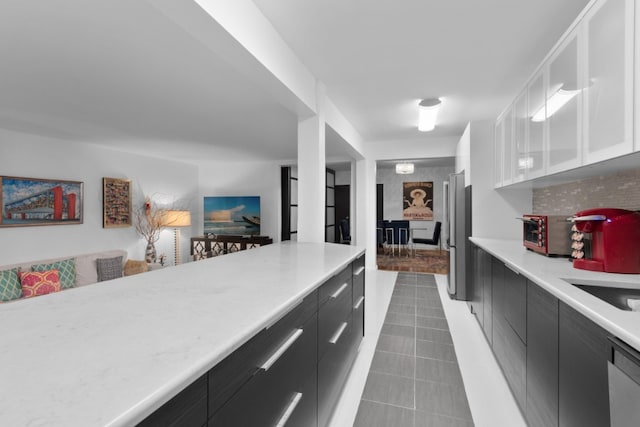 79-10 34th Ave Unit 3S, New York City, NY 11372 - kitchen with dark cabinets, light countertops, stainless steel dishwasher, white cabinetry, and tile patterned flooring
