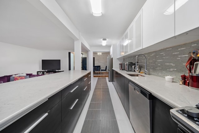 79-10 34th Ave Unit 3S, New York City, NY 11372 - kitchen featuring a sink, stainless steel dishwasher, dark cabinetry, white cabinetry, and decorative backsplash