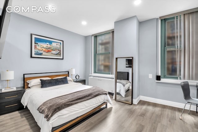 bedroom with wood finished floors, baseboards, and recessed lighting