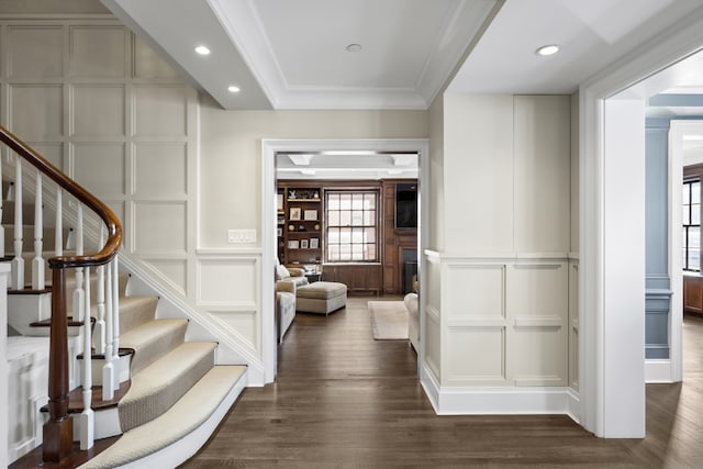 333 E 68th Street Penthouse, New York City, NY 10065 - hallway with a decorative wall, stairs, dark wood-style flooring, crown molding, and recessed lighting